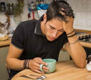 Tired Man with Coffee Sitting at Kitchen Table